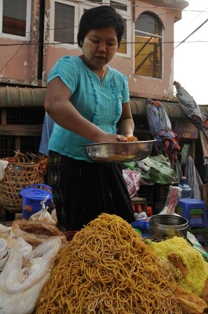 preparação da let thoke, uma salada à base de massa, legumes frescos como tomate e couve, com muitos anónimos e indecifráveis condimentos, tudo ligado com farinha de grão e misturado com as mãos