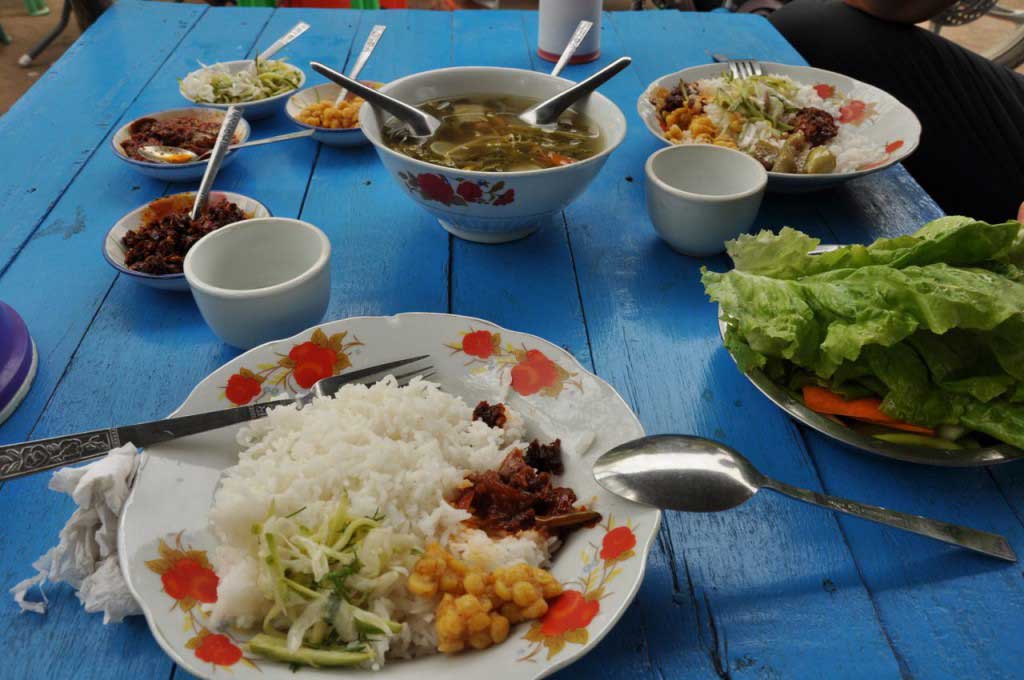 refeição típica birmanesa, com sopa e vários acompanhamentos que se misturam com o arroz
