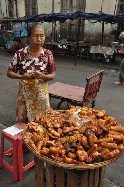 Numa das ruas de Yangon, encontram-se pequenas bancas de venda de comida, em especial durante a manhã, altura em que os fritos são muito populares, seja bananas seja somente de massa simples, recheada de lentilhas ou grão